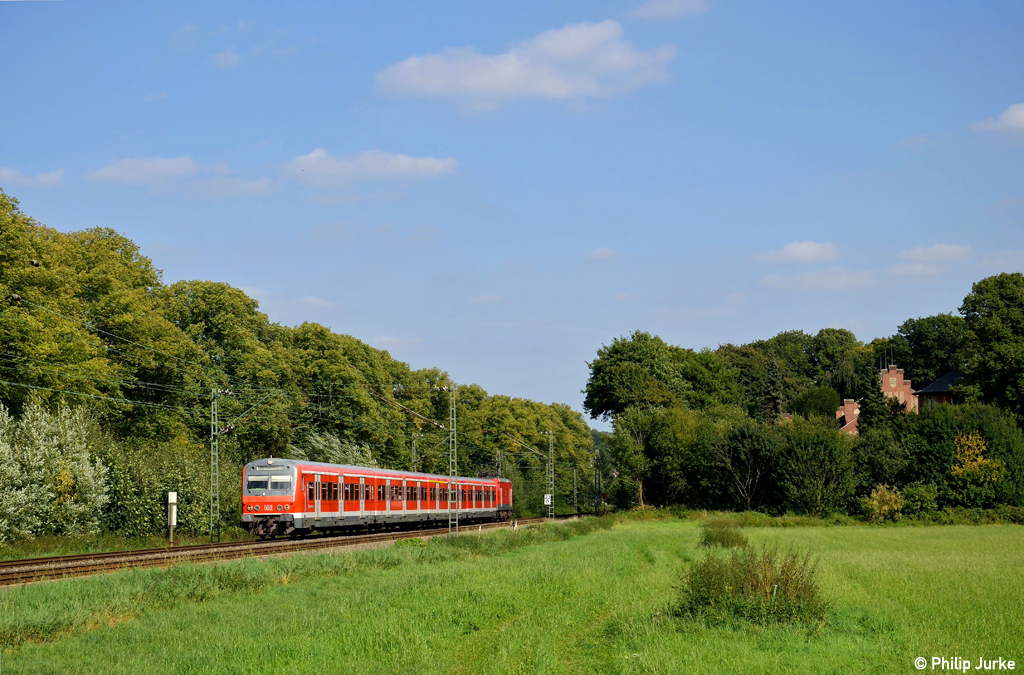 143 215-2 schiebt die S6 nach Kln-Nippes am 16.09.2012 durch einen kleinen Einschnitt zwischen Essen-Werden und Essen-Kettwig.