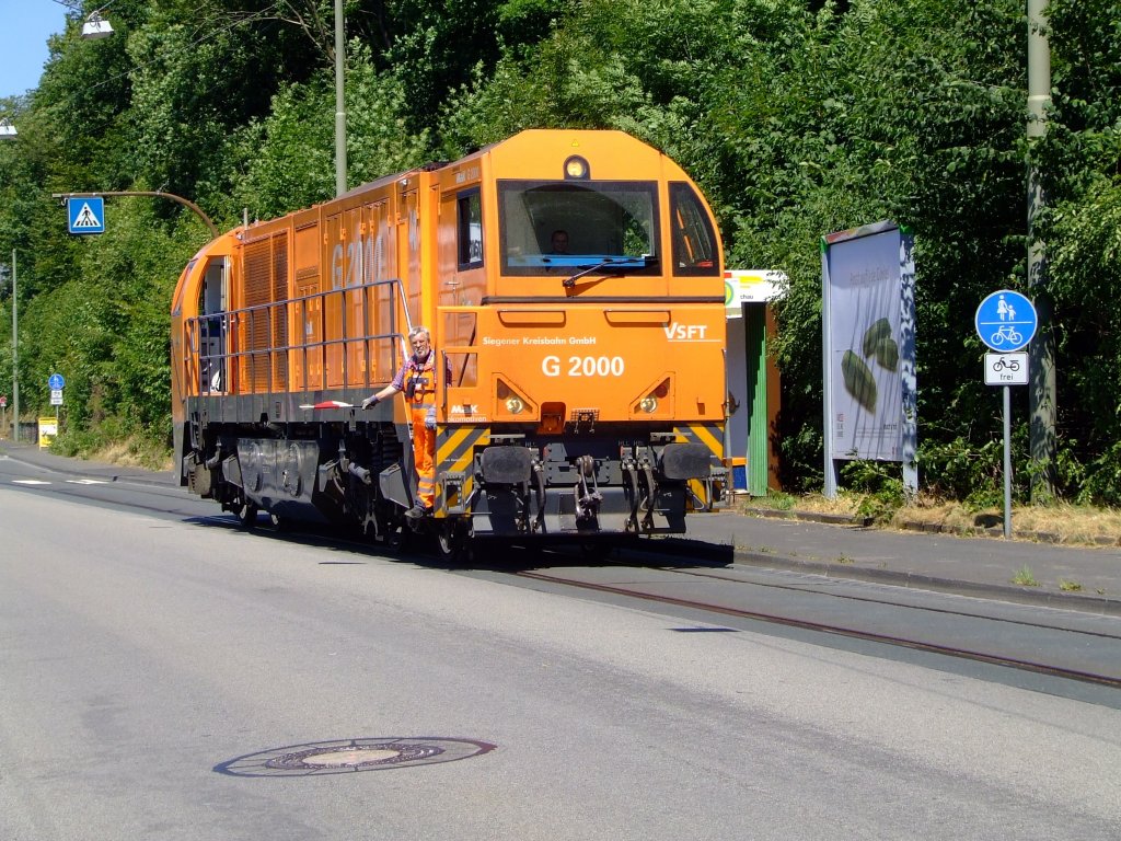 Die Mak G 2000 (Lok 43) der Kreisbahn Siegen-Wittgenstein fhrt in Siegen-Eintracht ber die Eiserfelder Strae (zum Gleisanschu Rhrenwerk)am 19.07.2006. Das Gleis ist mittlerweile neben die Strae neu verlegt worden.