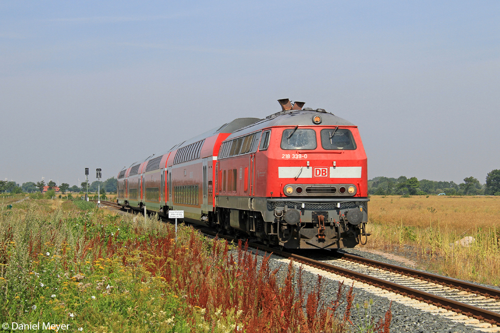Die 218 339-0 mit dem RE von Puttgarden nach Hamburg bei Burg auf Fehmarn am 28.07.2013
