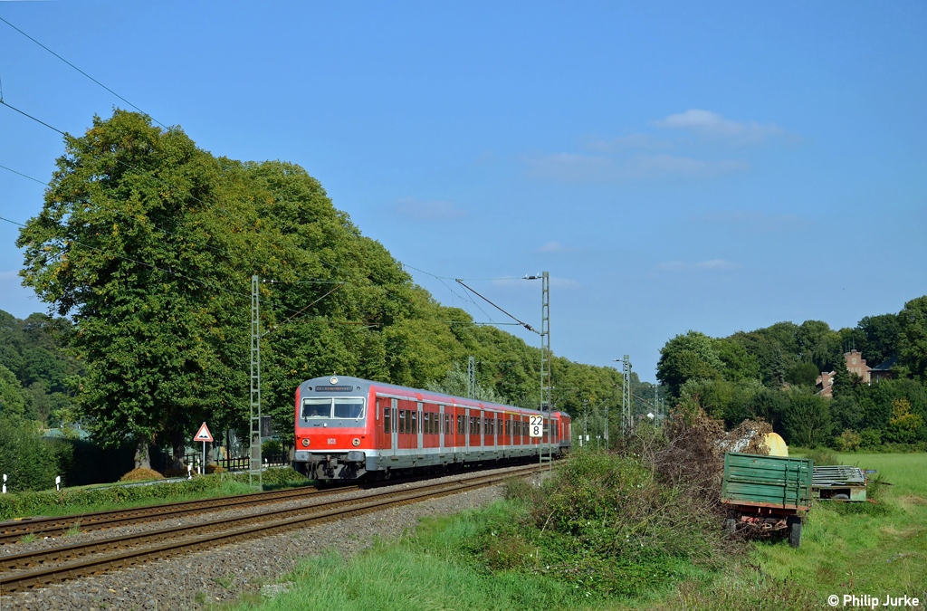 143 823-3 schiebt die S6 nach Kln-Nippes am 16.09.2012 durch einen kleinen Einschnitt zwischen Essen-Werden und Essen-Kettwig.