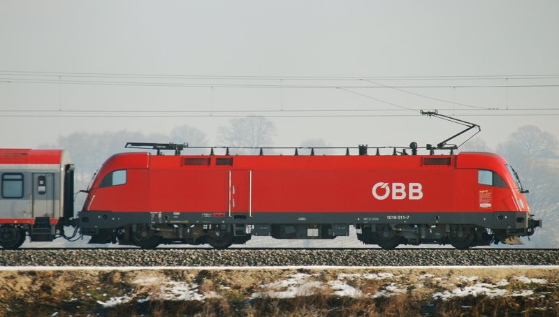Der Taurus mit der kleinen, unscheinbaren  Zug-Kraft -Werbung unter dem Seitenfenster! 1016 011-7, aufgenommen am 19.01.10, als Zuglok des EC 113, auf der Strecke Ulm-Augsburg, kurz nach Burgau.